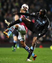 Fabian Delph berebut bola dengan Yaya Toure. AFP/Paul Ellis.