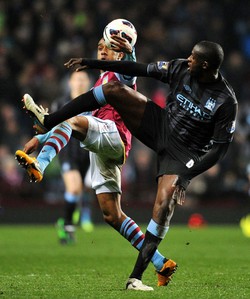 Fabian Delph berebut bola dengan Yaya Toure. AFP/Paul Ellis.