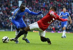 Patrice Evra berusaha menghentikan serangan yang dilakukan Victor Moses. Reuters/Russell Cheyne.