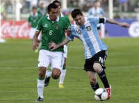 Lionel Messi melakukan serangan dengan pengawalan ketat Walter Veizaga. Reuters/Gaston Brito.