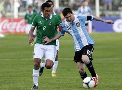 Lionel Messi melakukan serangan dengan pengawalan ketat Walter Veizaga. Reuters/Gaston Brito.