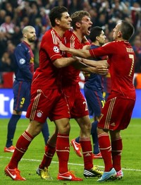 Thomas Muller merayakan gol yang dibuatnya bersama Franck Ribery dan Mario Gomez. Reuters/Michael Dalder.