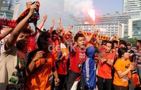 Puluhan suporter The Jak Mania, membakar kembang api, dalam aksi demonya, di Bunderan HI, Jakarta, Minggu (05/05).