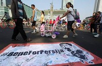 Sejumlah warga yang tengah melakukan aktifitas olahraga, melintas di depan spanduk Bepe For Persija, yang telah ditanda tangani oleh para suporter The Jak Mania.