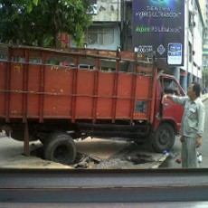 Injak Tutup Selokan, Truk Bermuatan Besi Terperosok