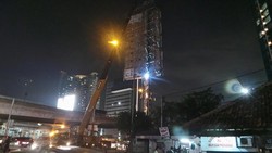 Petugas Perbaiki Papan Reklame yang Doyong di Perempatan Slipi