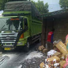 Truk Muat Bahan Bangunan Terguling Setelah Tabrak Pohon