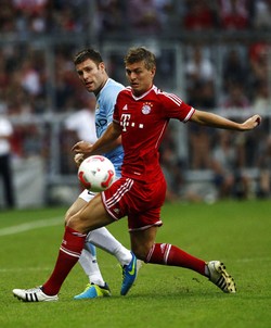 James Milner berebut bola dengan Toni Kroos. Reuters/Michaela Rehle.