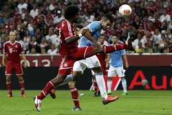 Alvaro Negredo yang mendapat pengawalan dari Dante berusaha menanduk bola. Dalam pertandingan ini, Negredo berhasil menjebol gawang Bayern di menit ke-61. Reuters/Michaela Rehle.