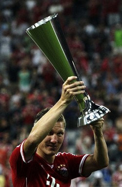 Bastian Schweinsteiger mengarak trofi Audi Cup 2013. Reuters/Michaela Rehle.