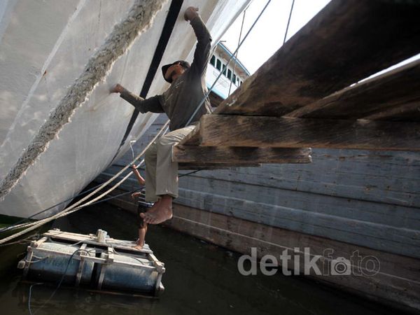Masih Libur, Para ABK Mengecat Lambung Kapal