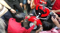 Jokowi Bubuhkan Tanda Tangannya di Vespa Banteng Kader PDIP