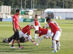 Anak-anak dari SSB Tugu Muda, Semarang, melakukan peregangan, diawasi oleh asisten pelatih, Heri. Indonesia selalu mengirim wakilnya ke Danone Nations Cup sejak 2003. Final dunia tahun ini digelar di Stadion Wembley, London, Inggris.