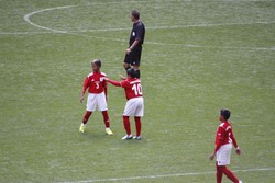 Kapten Indonesia, Saddam Baihaki (nomor 10) sedang memberi sebuah komando kepada Kanu Helmiawan dalam pertandingan melawan Amerika Serikat di Stadion Wembley.
