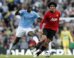 Yaya Toure berebut bola dengan Marouane Fellaini. Reuters/Phil Noble.