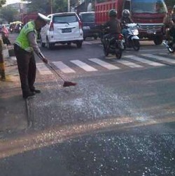 Salut! Polisi Ini Inisiatif Bersihkan Pecahan Kaca di Jalan