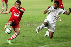 Michael Owen (kiri) saat mengeksekusi tendangan yang dihadang oleh pemain belakang lawan dari tim Indonesia Red, Bejo Sugiantoro (kanan).