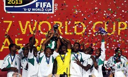 Para pemain Nigeria mengangkat trofi Piala Dunia U-17. AFP/Karim Sahib.