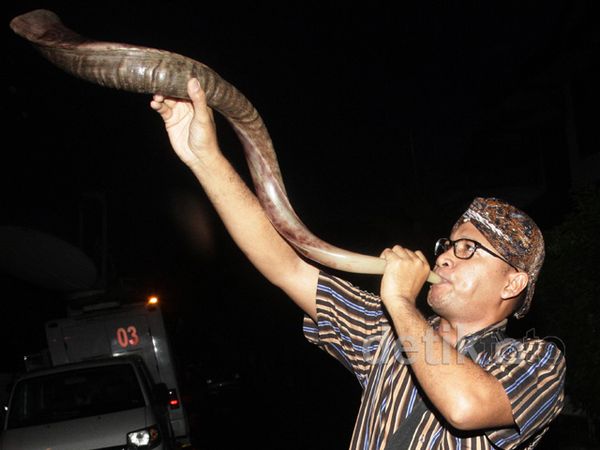 Pria Berblangkon Tiup Terompet di Rumah Anas