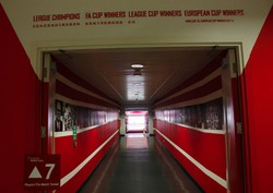 Lorong memasuki museum Arsenal di Emirates Stadium. Merah adalah warna dominan stadion ini.