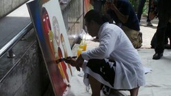  Dukung Pemberantasan Korupsi, Seniman Holis Satriawan Melukis di Depan KPK