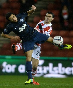 Rafael berusaha menghadang serangan Oussama Assaidi dalam pertandingan di Britannia Stadium, Kamis (19/12/2013) dinihari WIB. AFP/Andrew Yates.