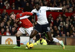 Wayne Rooney (kiri) berebut bola dengan Emmanuel Adebayor (kanan) dalam pertandingan di Old Trafford. Reuters/Nigel Roddis.