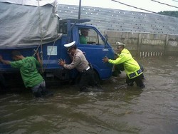 Terjang Banjir, Perwira Polisi Dorong Truk yang Mogok di Puri Kembangan