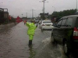 Bersepatu Boot, Polwan Ini Atur Lalin Tol Bandara yang Tergenang