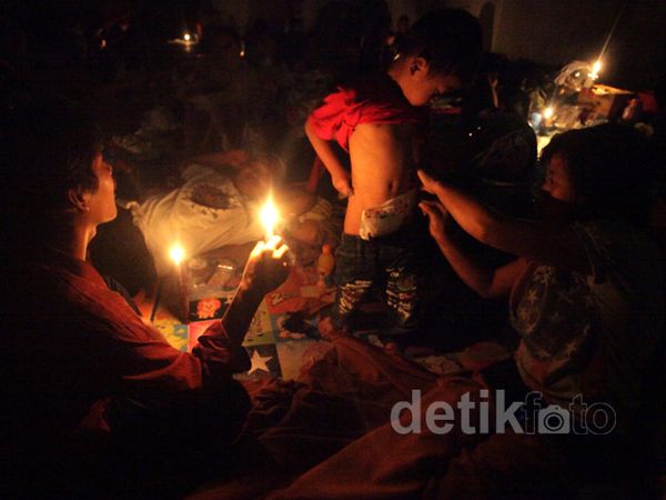 Lilin Kecil Terangi Lokasi Pengungsian