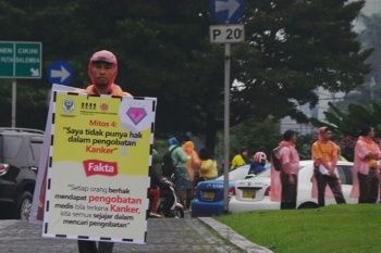 Hujan Tak Halangi Aksi Bagi-bagi Bunga di Hari Kanker Sedunia