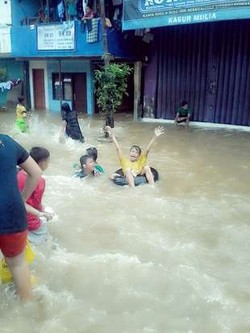 Anak-anak di Kampung Pulo Jadikan Lokasi Banjir Seperti Water Boom