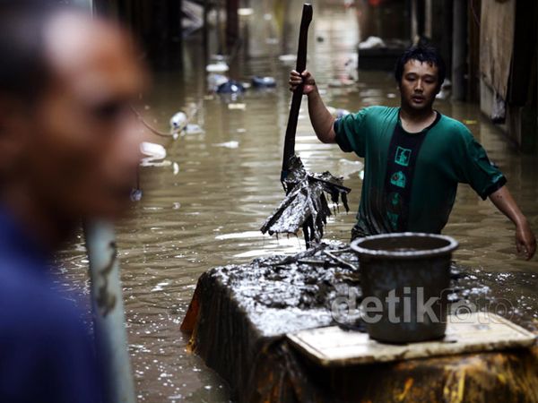 Membersihkan Lumpur dan Sampah Sisa Banjir
