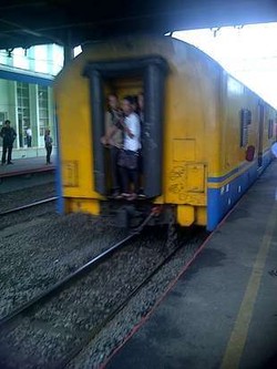Tak Kebagian Tempat, Penumpang KA Ini Malah Bergantungan di Pintu Keluar