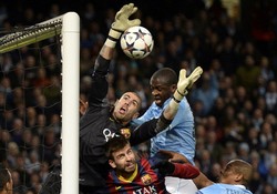 Victor Valdes melompat untuk mengamankan gawangnya dari serangan para pemain Manchester City. Reuters/Nigel Roddis.