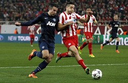 Robin van Persie berebut bola dengan salah satu pemain Olympiakos Kostas Manolas. (REUTERS/Yorgos Karahalis).     