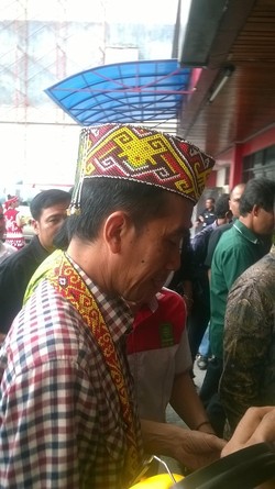 Tiba di Pontianak, Jokowi Dipakaikan Topi dan Kain Tradisional