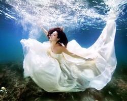 Foto-foto Dramatis Wanita Berpose dengan Gaun Pengantin di Bawah Air