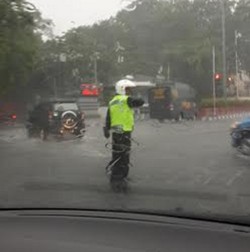 Luar Biasa! Di Tengah Hujan Badai Polisi ini Tetap Atur Lalin di HI