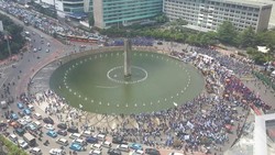 Buruh Duduk-duduk dan Foto-foto di Tengah Jalan di HI, Kendaraan Melintas Perlahan