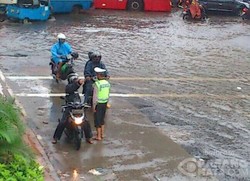 Polisi Bersandal Jepit Atur Lalu Lintas Matraman yang Kacau Akibat Banjir