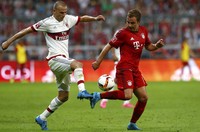 Mario Goetze (kanan) berebut bola dengan Luca Antonelli (kiri). Dalam pertandingan ini Goetze menyumbangkan satu gol untuk Bayern Munich di menit ke-74. Michaela Rehle/Reuters/detikFoto.