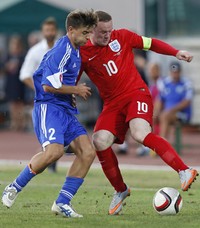 Wayne Rooney berusaha melewati Giovanni Bonini. Carl Recine/Reuters/detikFoto.