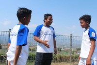 Dua pemain bersenda gurau dengan pelatihnya, Adi Putra Setiawan.