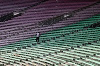 Pekarja membersihkan tribun stadion.