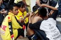 Suporter harus tampil atraktif. Seorang suporter mencukur seorang temannya.