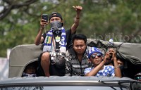Beberapa suporter tampak berdiri di atas truk saat dikawal memasuki kawasan GBK.