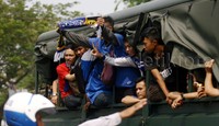 Seorang suporter terlihat membentangkan syal bertuliskan Persib.     
