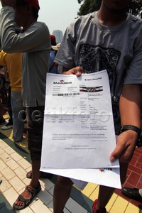 Seorang supporter menunjukan bukti pembelian tiket sebelum ditukarkan ke tiket box. Pool/Alfathir Yulianda/detikFoto.
