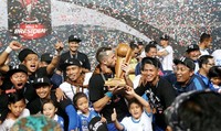 Seorang pemain Persib tampak mencium trofi piala kemerdekaan.
